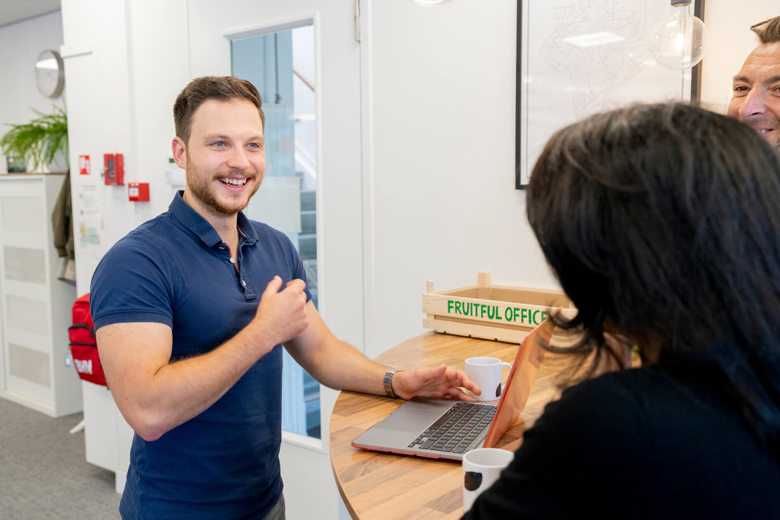 Collega lacht achter laptop