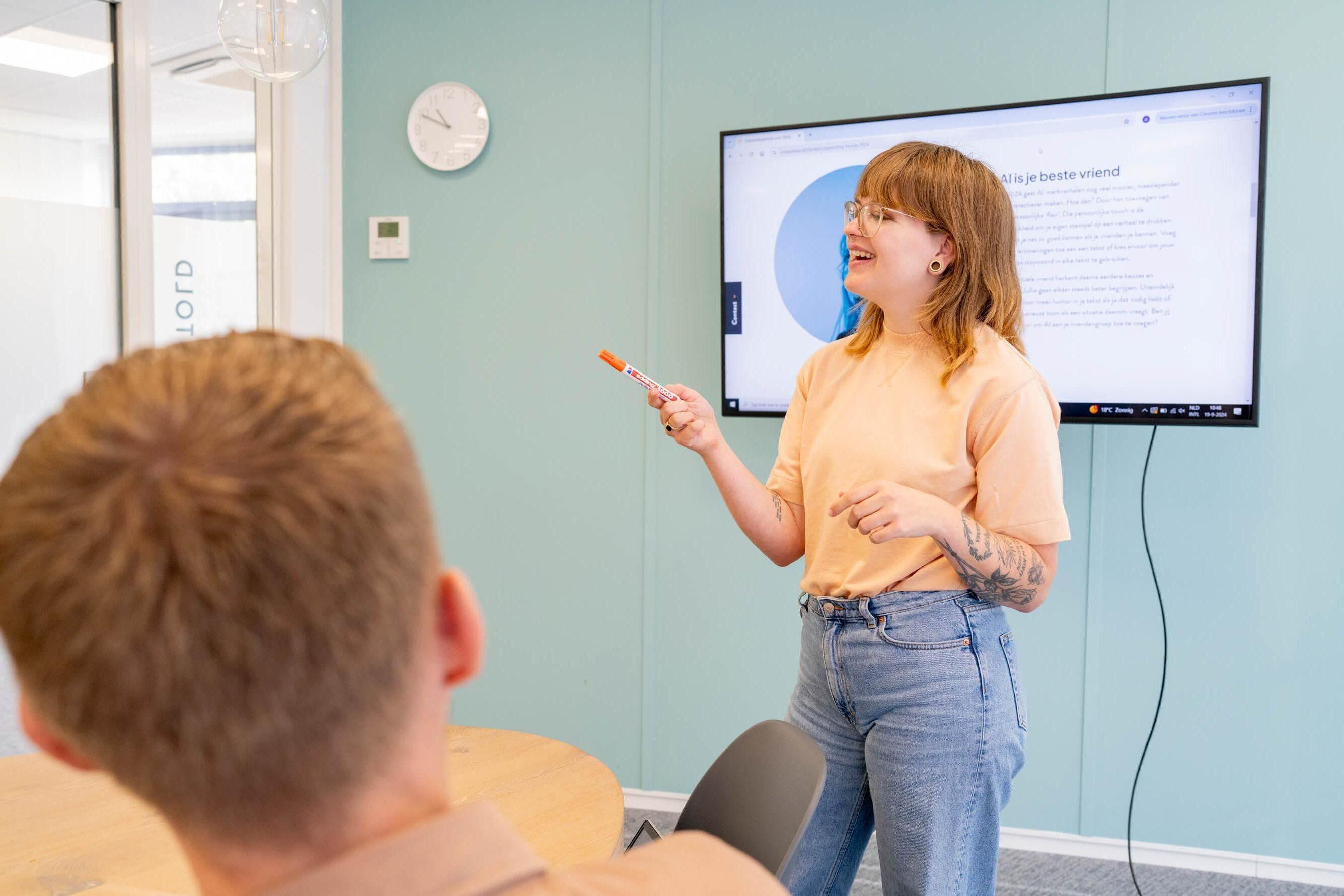 Persoon geeft een presentatie met een scherm op de achtergrond