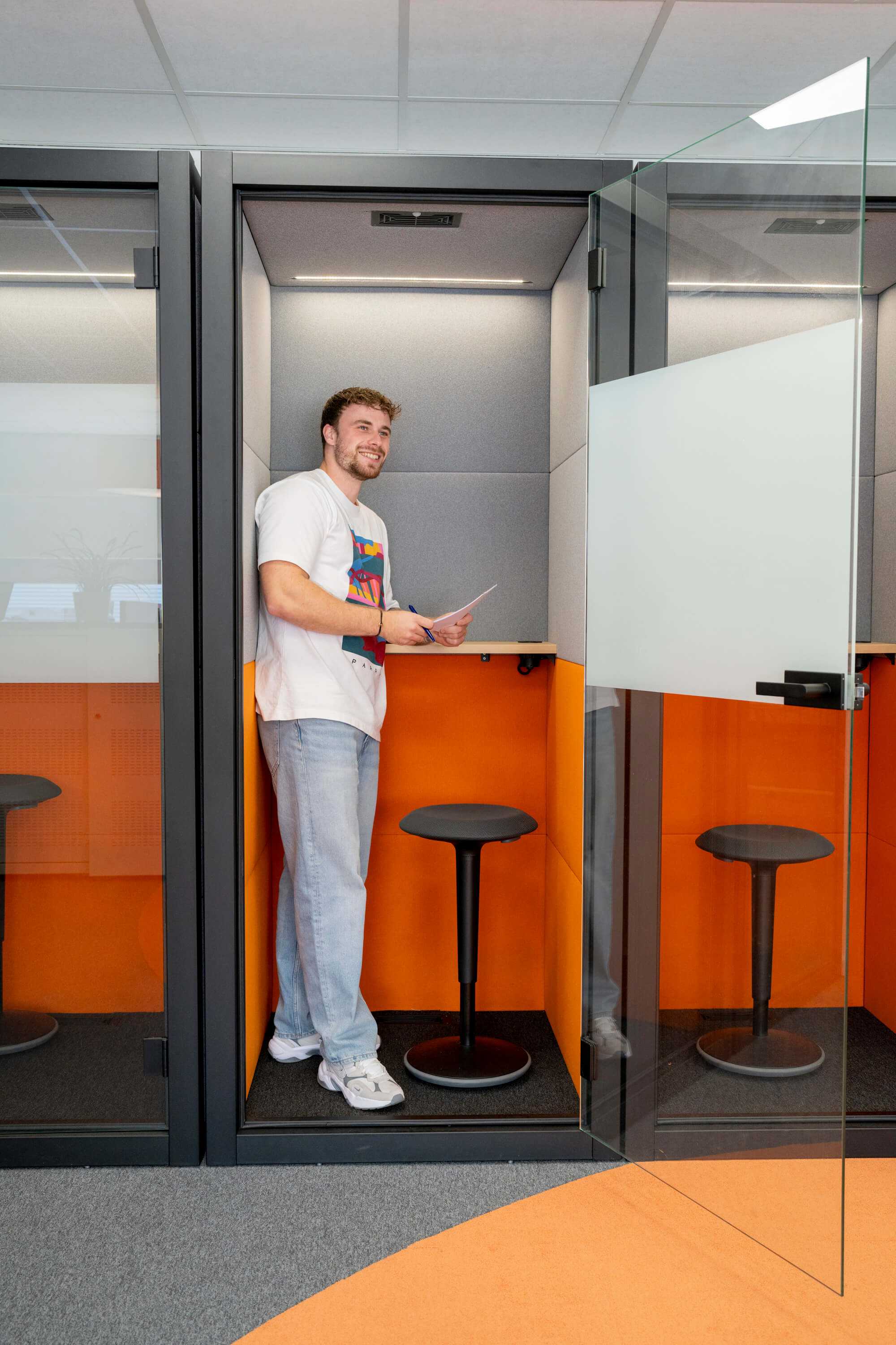Man staat met notitieblok in een belhokje