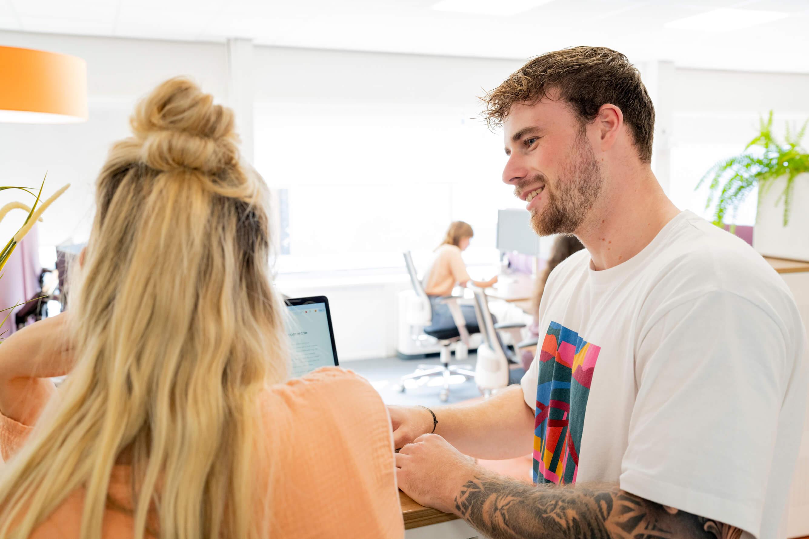 Collega's in gesprek bij een laptop op kantoor