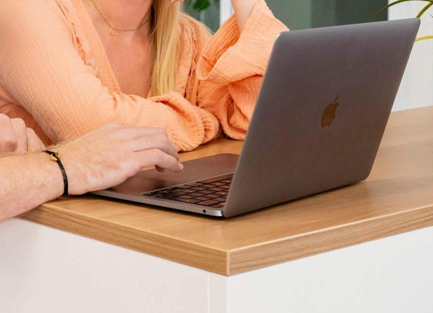 Twee collega's achter een laptop